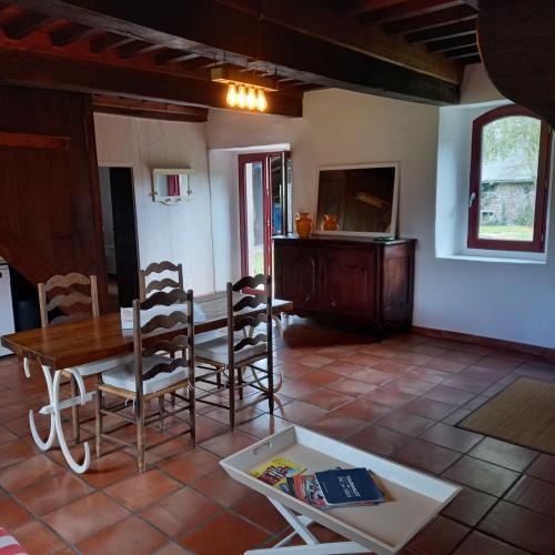 a living room with a wooden table and chairs at Maison de campagne 