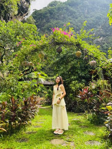 a woman in a yellow dress standing in a garden at Green Valley Homestay - Thung Lũng Xanh in Nguyên Ngoại
