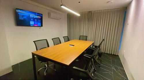 a conference room with a wooden table and chairs at Flat sofisticado na Praia do Cabo Branco 4 pessoas in Tambaú