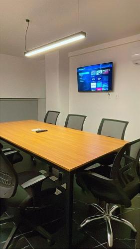 a conference room with a wooden table and chairs at Flat sofisticado na Praia do Cabo Branco 4 pessoas in Tambaú