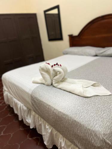 a bed with two folded towels on it at Mi Pension in San Pedro Sula