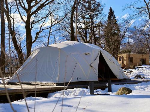 a tent is sitting in the snow at Snow Peak LAND STATION HAKUBA in Hakuba