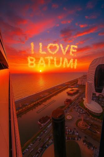Una puesta de sol con las palabras "Amo a Batman" en el cielo. en Orbit apartments near the beach, en Angisa