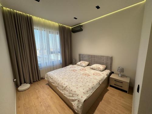 a bedroom with a bed and a large window at Golden House Oz'Makon in Tashkent