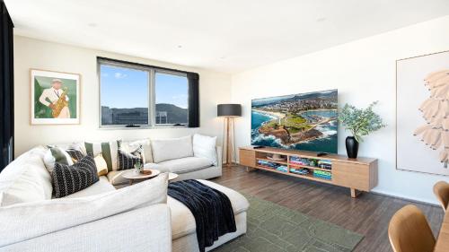 a living room with a white couch and a tv at Burelli Beauty in Wollongong