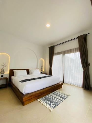a bedroom with a large bed and a large window at Sagunalam Tetebatu in Tetebatu