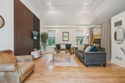 a living room with two couches and a table at Niagara on the Lake Walkable Old Town Retreat in Niagara on the Lake
