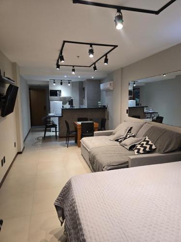 a large room with two beds and a kitchen at Loft Prainha in Arraial do Cabo