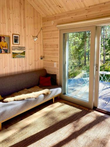 a room with a couch and a large sliding glass door at Cosy Guest House At Ekstakusten in Fröjel