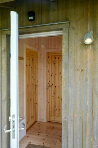 an open door in a room with wooden walls at Cosy Guest House At Ekstakusten in Fröjel