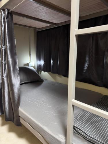 a bedroom with a bunk bed with black curtains at BaanKhamSuk in Chiang Mai