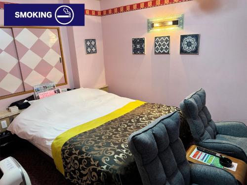 a hotel room with a bed and a chair at Restay lagoon in Tokyo