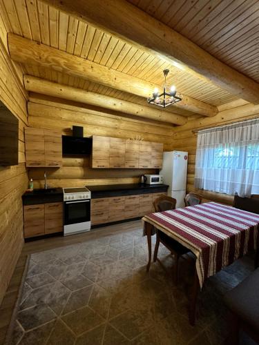 a dining room with a table and a kitchen at Над рікою Міжгірʼя in Mizhhirʼʼya
