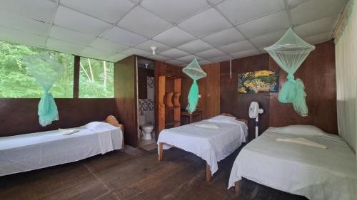 a room with two beds and a toilet at Jacamar Lodge Expeditions in Iquitos