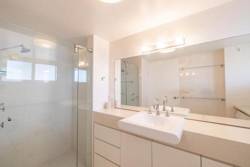 une salle de bain blanche avec un lavabo et une douche dans l'établissement Albacore 5, à Nelson Bay