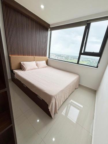 ein Bett in einem Zimmer mit einem großen Fenster in der Unterkunft New Moon homestay- Nera garden Huế in Thôn Văn Dương