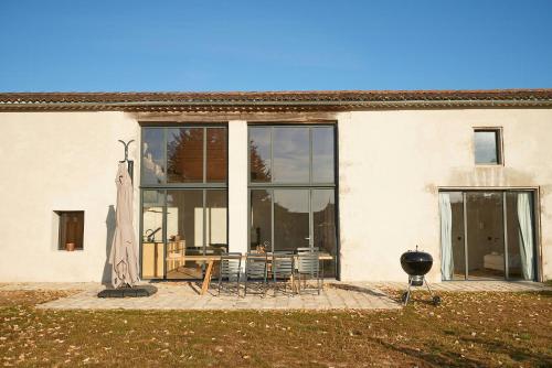 a building with a table and chairs in front of it at Restored Farm Estate Near Atlantic Coast France in La-Gripperie-Saint-Symphorien