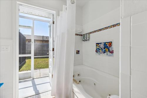 Un baño blanco con bañera y ventana. en 4880 N Banana River Sandys Place, en Cocoa Beach