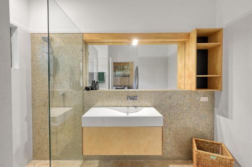 a bathroom with a sink and a mirror at Pandanus Retreat in Point Lookout