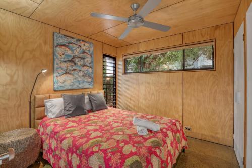 a bedroom with a bed and a ceiling fan at Pandanus Retreat in Point Lookout