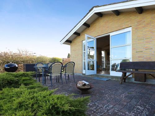 a patio with chairs and a table in front of a house at 6 person holiday home in Frørup in Frørup