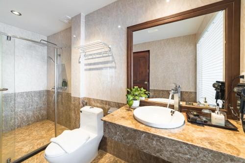 a bathroom with a toilet and a sink and a shower at Xaysomboun Hotel & SPA in Vientiane
