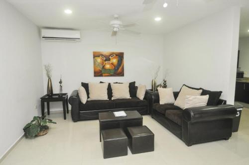 a living room with two couches and a table at Phenomenal Location Near Beach & 5th with Stunning Roof Pool in Playa del Carmen