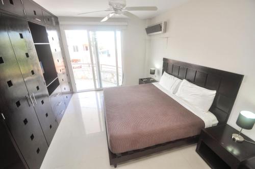 a bedroom with a bed and a ceiling fan at Phenomenal Location Near Beach & 5th with Stunning Roof Pool in Playa del Carmen