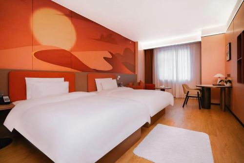 a bedroom with a large white bed and a desk at Quanzhou Binhai Hotel in Quanzhou