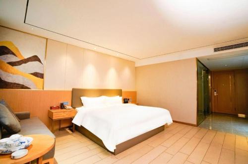 a bedroom with a bed and a table and a couch at Quanzhou Binhai Hotel in Quanzhou