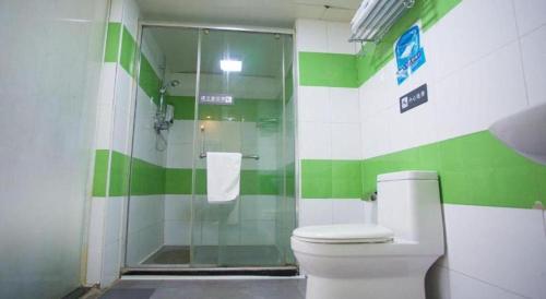 a green and white bathroom with a toilet and a shower at 7 Days Inn Jinan Changqing Jingshi West Road Center in Jinan