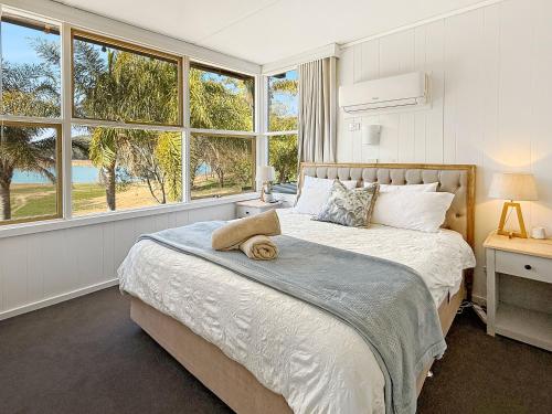 Un dormitorio con dos camas y una gran ventana. en Lakefront Palms, en Bonnie Doon