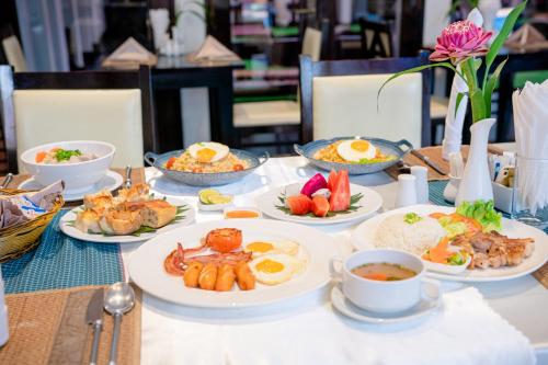 a table with plates of breakfast food on it at Sokchea Angkor Hotel in Siem Reap