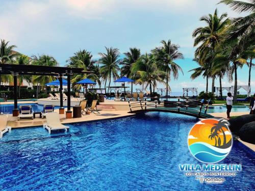 a swimming pool at a resort with palm trees at Villa Medellin Monterrico in Taxisco