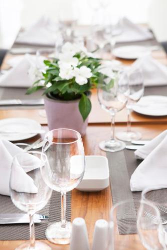 a table with wine glasses and a plant on it at Sofitel Beirut Le Gabriel in Beirut