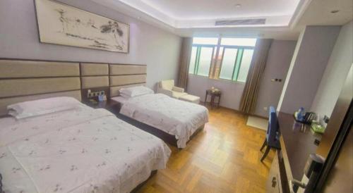 a hotel room with two beds and a television at Li An Hotel Shantou Xiashan Central Bus Station Branch in Shantou