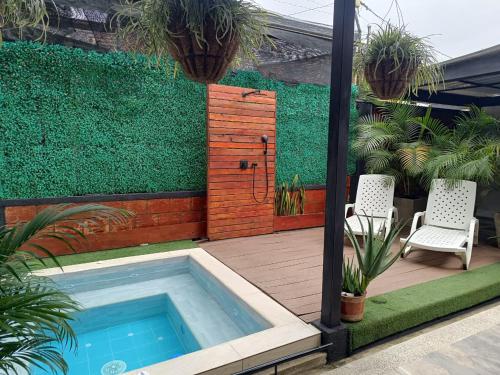 a patio with a swimming pool and two chairs and plants at Casa Luna Lago Calima in Calima