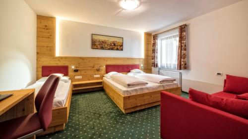 a hotel room with two beds and a couch at Hotel Elisabeth in Chienes