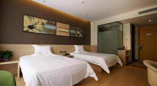 two beds in a hotel room with white sheets at IU Hotel Zhangye High-Speed Railway Station in Zhangye