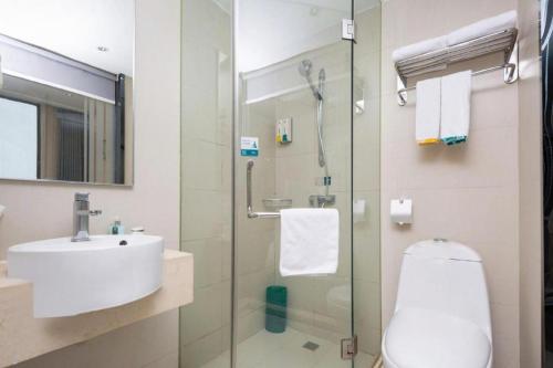 a bathroom with a sink and a glass shower at City Comfort Inn Wuhan Zhongnan Road Fujiaopo in Wuhan