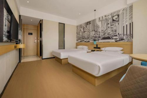 a hotel room with two beds and a television at City Comfort Inn Liuzhou Wuling Liutai Road in Liuzhou