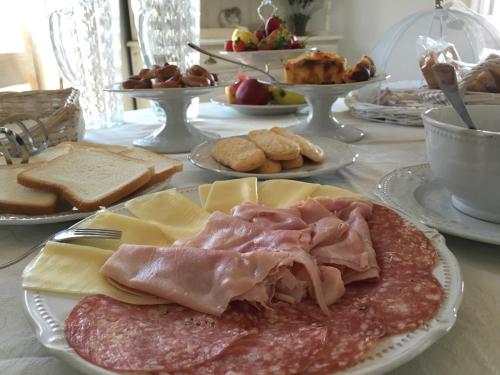 a table with plates of meat and cheese and bread at Monti di Jogliu in Arzachena