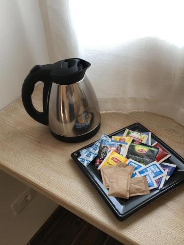 a table with a tea kettle and a tray of food at Monti di Jogliu in Arzachena