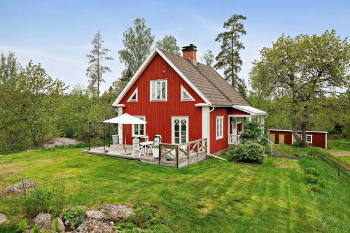 a red house with a deck on a lawn at Villa Berget in Fröseke