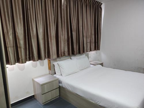 a bedroom with a white bed and a window at Kozi Hotel - Bukit Indah in Johor Bahru