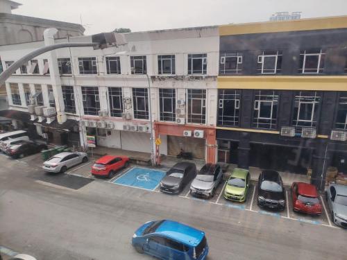 a parking lot with cars parked in front of a building at Kozi Hotel - Bukit Indah in Johor Bahru