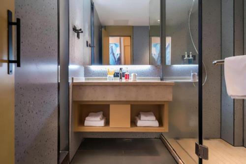 a bathroom with a sink and a shower at City Comfort Inn Huanggang Wuxue Bus Center in Wuxue