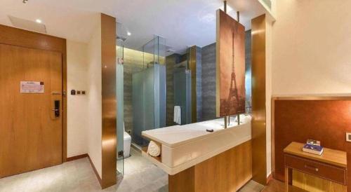 a bathroom with a sink and a glass shower at James Joyce Coffetel Shijiazhuang the Mixc Jinyuan Tower Airport Bus in Shijiazhuang