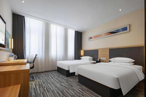 une chambre d'hôtel avec deux lits et une télévision dans l'établissement City Comfort Inn Hefei Binhu Wanda Plaza, à Hefei