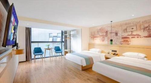 a hotel room with two beds and a flat screen tv at City Comfort Inn Kunming High Speed Railway South Station Yongxin Harvard in Kunming